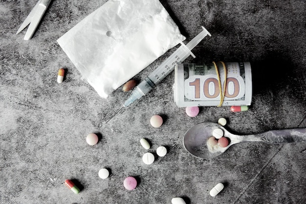 Zdjęcie koncepcja uzależnienia od narkotyków z pakietem heroiny i strzykawką na czarnym tle