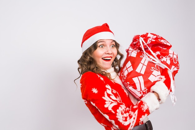 Koncepcja wakacje, Boże Narodzenie i ludzie - kobieta z zaskoczoną buźką w stroju świętego mikołaja z torbą prezentów