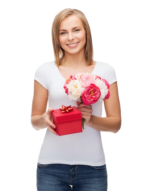 Zdjęcie koncepcja wakacje, miłość i kwiaty - młoda kobieta z bukietem kwiatów i czerwonym pudełkiem na prezent