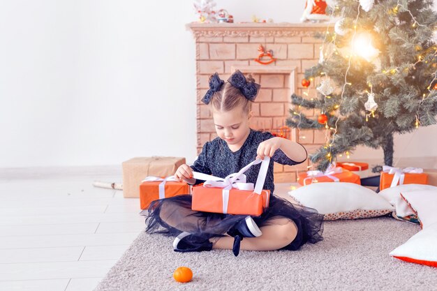 Koncepcja wakacji i dzieciństwa - portret małej szczęśliwej słodkiej dziewczyny z prezentem świątecznym