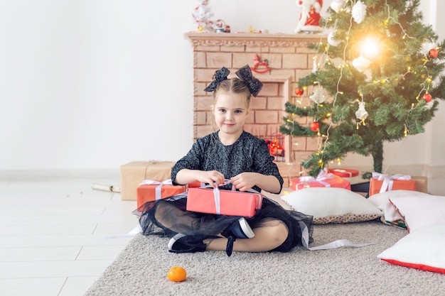 Koncepcja wakacji i dzieciństwa - portret małej szczęśliwej słodkiej dziewczyny z prezentem świątecznym