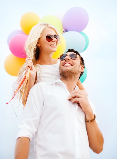 koncepcja wakacji letnich, uroczystości i randek - para z kolorowymi balonami