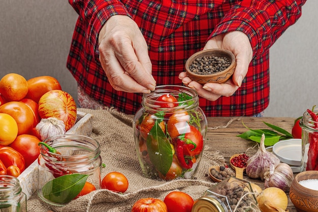 Koncepcja warzyw sezonowych Zbiór pomidorów, chili, cebuli i czosnku Ręce kobiety przygotowują składniki do procesu gotowania żywności w puszkach Zdrowe przepisy kulinarne miejsce na kuchnię domową