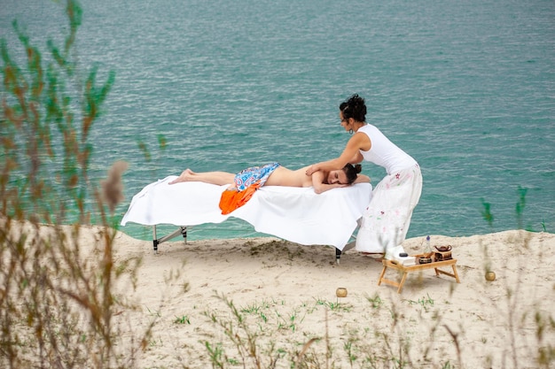 koncepcja wellness, urody i relaksu - piękna młoda kobieta leżąca i mająca masaż pleców w spa