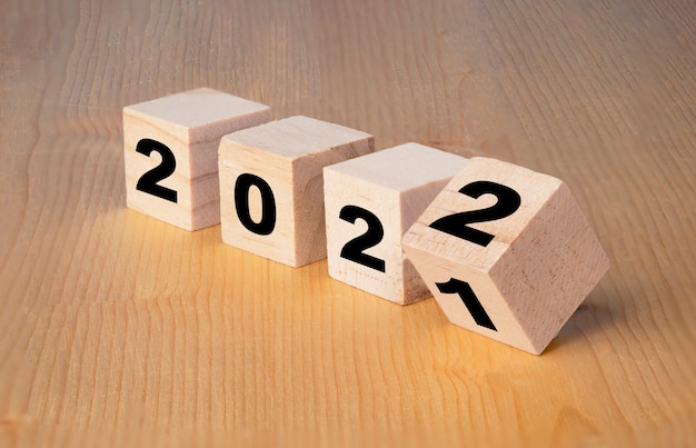 Koncepcja Wesołych Świąt i szczęśliwego nowego roku, Odwracanie drewnianego bloku kostki zmienia się z 2021 na 2022.