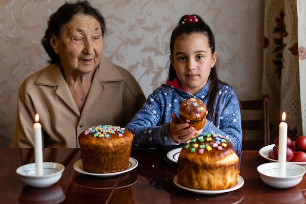 Koncepcja Wielkanocy. Babcia z wnuczką trzymają w domu pisanki.