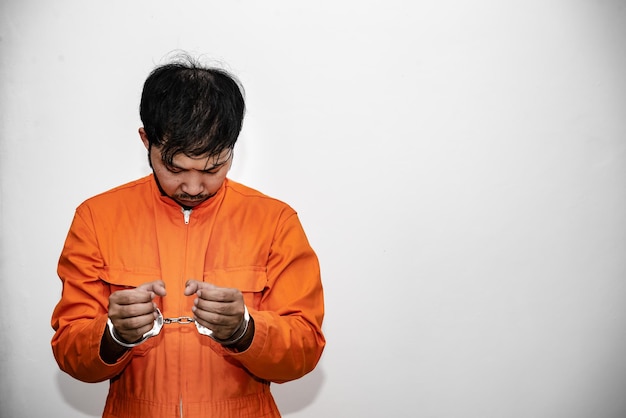 Koncepcja więźnia w pomarańczowych szatach Portret przystojnego azjatyckiego mężczyzny w więziennych mundurach Bandyta ma dużo mięśni