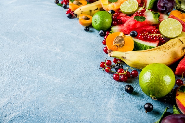 Zdjęcie koncepcja witamin, różne owoce i jagody arbuz brzoskwinia mięta śliwki morele borówki porzeczki