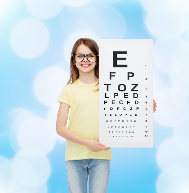 Koncepcja Wizji, Zdrowia I Ludzi - Uśmiechnięta Dziewczynka W Okularach Z Wykresem Sprawdzania Oczu