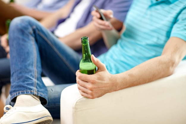 koncepcja wypoczynku, ludzi i alkoholu - zbliżenie męskich przyjaciół pijących piwo w domu