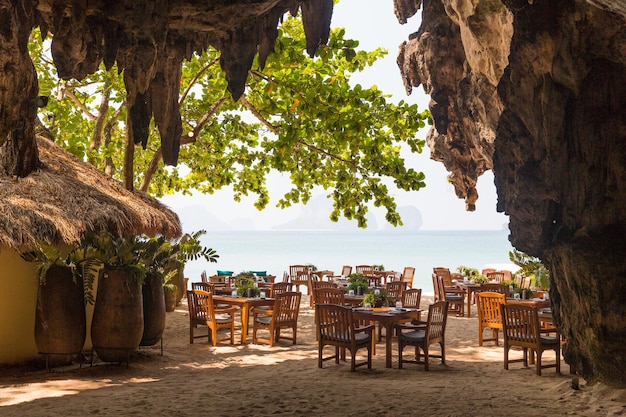 Koncepcja Wypoczynku, Podróży I Turystyki - Widok Na Restaurację Na świeżym Powietrzu Na Plaży Z Jaskini