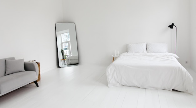 Koncepcja wystroju wnętrz w białym nowoczesnym mieszkaniu. Przytulna sypialnia z wystrojem domu, roślina doniczkowa, strona