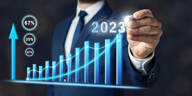 Koncepcja wzrostu biznesu w 2023 roku biznesmen rysuje wykres planowania nowej strategii celów i możliwości wzrostu