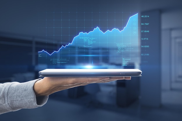 Koncepcja wzrostu giełdy z cyfrowym ekranem z wykresem wzrostu finansowego i wskaźnikami wyświetlanymi z cyfrowego tabletu na kobiecej dłoni