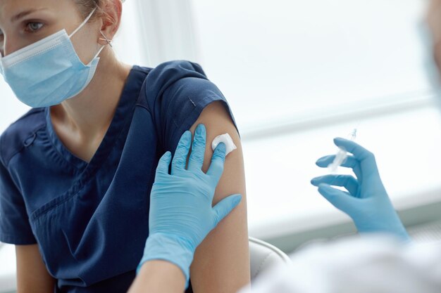 Koncepcja zapobiegania chorobom związanym ze szczepieniami Kobieta w medycznej masce na twarz otrzymująca szczepionkę Covid19