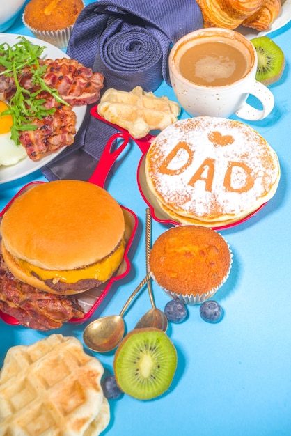 Koncepcja zaproszenia restauracji dzień ojców brunch. Różne tło menu dnia taty mężczyzny, z tradycyjnym zestawem śniadaniowym i obiadowym, z krawatem na słonecznym jasnym niebieskim tle