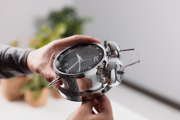 Koncepcja zarządzania czasem. Męska ręka dostosowująca lub zmieniająca czas na zegarze.