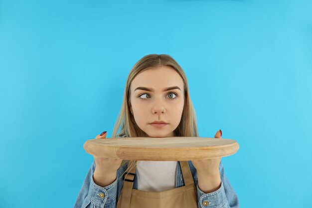 Zdjęcie koncepcja zawodu młoda kelnerka na niebieskim tle