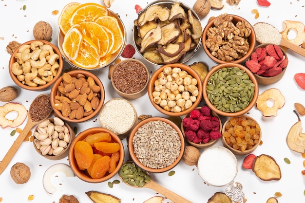 Koncepcja zdrowego odżywiania Asortyment superfoods na białym tle Suszone owoce, orzechy i nasiona
