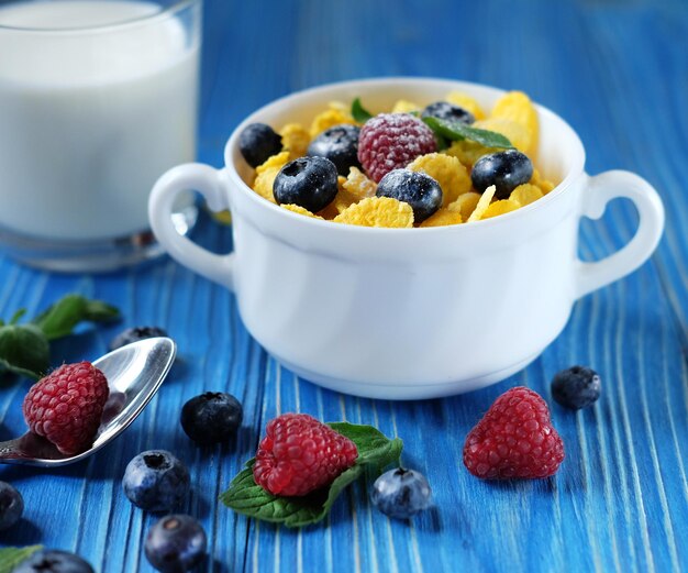 Koncepcja zdrowego odżywiania i diety Płatki kukurydziane ze świeżymi jagodami zbożowymi w misce i szklance z mlekiem