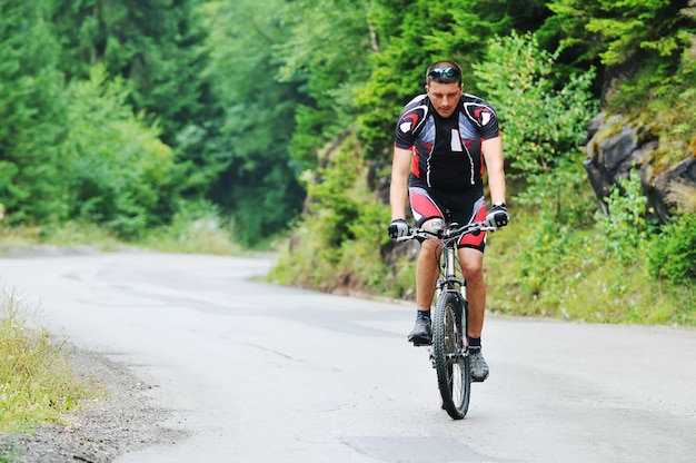 koncepcja zdrowego stylu życia i fitness z mężczyzną na rowerze górskim na świeżym powietrzu