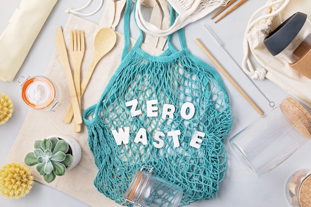 Koncepcja Zero Waste. Zestaw Ekologicznych Bambusowych Sztućców, Bawełniana Torba Z Siateczki, Kubek Do Kawy Wielokrotnego Użytku. Zrównoważone, Etyczne Zakupy, Styl życia Bez Plastiku. Widok Z Góry, Płaski Układ.