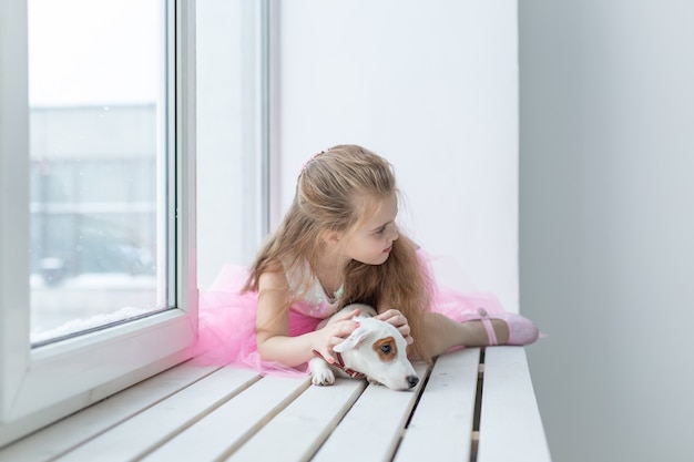 Koncepcja zwierząt domowych i dzieci - dziecko z psem Jack Russell Terrier w domu.