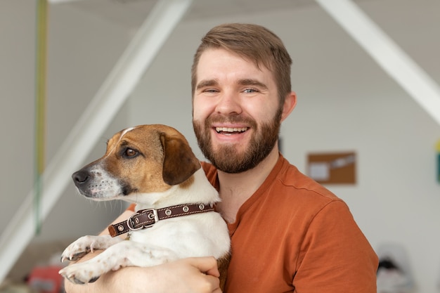 Koncepcja Zwierząt, Zwierząt Domowych I Ludzi - Przystojny Mężczyzna I Pies Domowy Jack Russell Terrier Stanowią Razem W Pomieszczeniu.