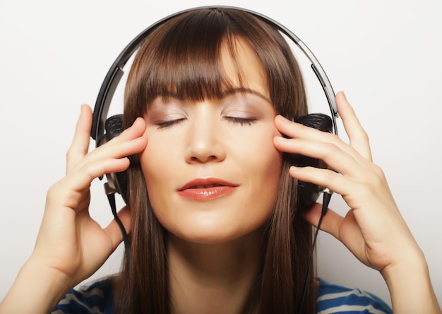 Koncepcja życia i ludzi młoda brunetka kobieta ze słuchawkami słucha muzyki