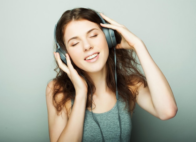 Koncepcja życia i ludzi młoda szczęśliwa kobieta ze słuchawkami słuchająca muzyki