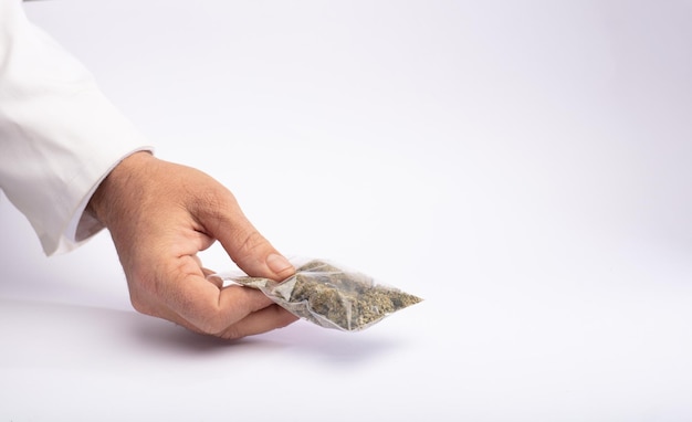 Konopie i narkotyki worek marihuany w rękach gest dostawy białe tło