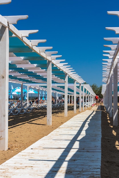 konstrukcje architektoniczne wykonane z drewna i białych leżaków na plaży nad Morzem Czarnym