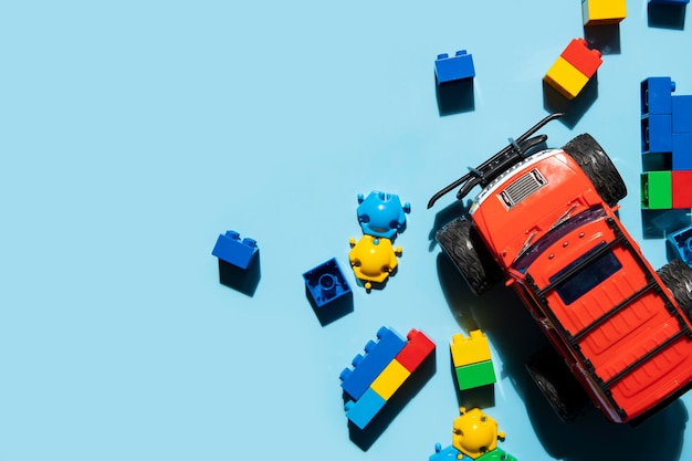 Konstruktor plastikowy i zabawkowy czerwony samochód jeep na niebieskim tle Widok z góry płaski lay