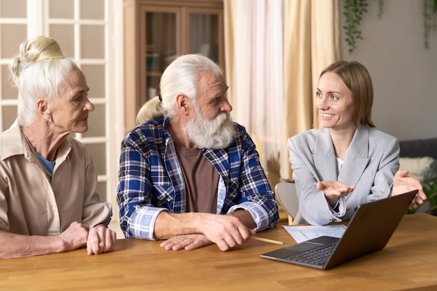 Zdjęcie konsultant finansowy rozmawiający ze starszą parą w domu
