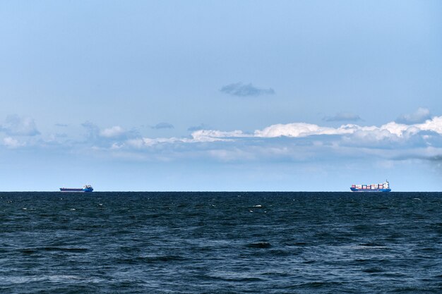 Kontenerowce na odległość, import i eksport, logistyka i transport handlowy, kontenerowce przewożą łodzie na otwartym błękitnym morzu. Transport morski, statek morski