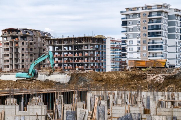 Koparka budowlana z łyżką na budowie na tle domów