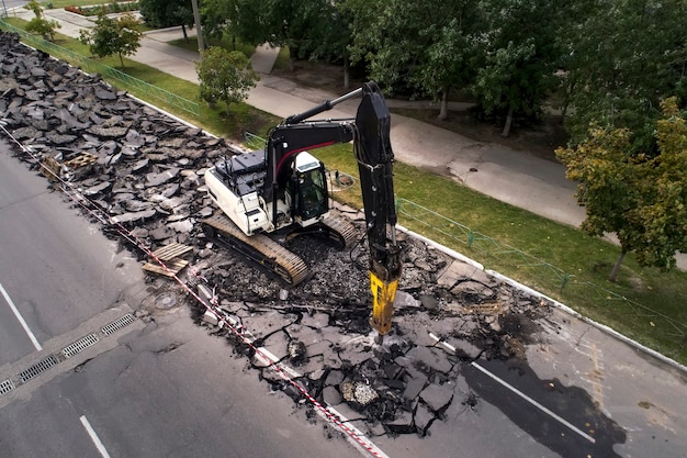 Koparka rozbijania nawierzchni betonowych przy pomocy wiertarki hydraulicznej przy naprawach drogowych.