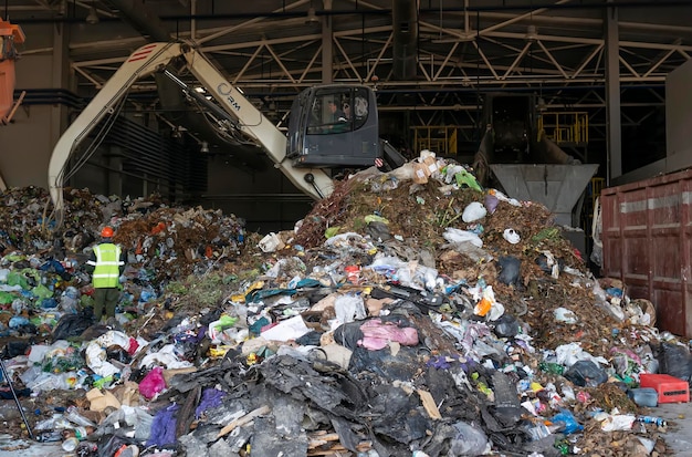 Zdjęcie koparka sortuje śmieci w zakładzie recyklingu odpadów