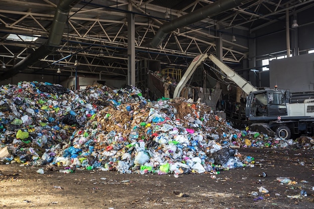 Koparka układa śmieci w wielki stos przy sortowni nowoczesny zakład przetwarzania odpadów Segregacja i segregacja śmieci Recykling i składowanie odpadów