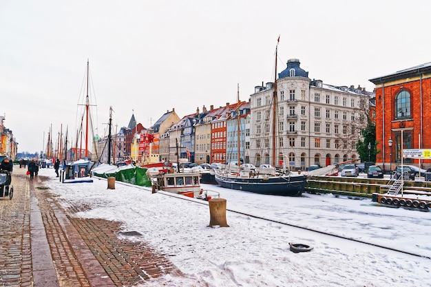 Kopenhaga, Dania - 5 stycznia 2011: Nyhavn (Nowy Port) zimą. Jest to nabrzeże, kanał, dzielnica rozrywki w Kopenhadze w Danii. Jest wyłożona kolorowymi domami, barami, kawiarniami, drewnianymi statkami