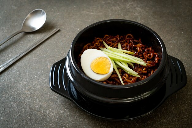 Koreański makaron błyskawiczny z sosem z czarnej fasoli pokryty ogórkiem i jajkiem na twardo (Jajangmyeon lub JJajangmyeon) - po koreańsku