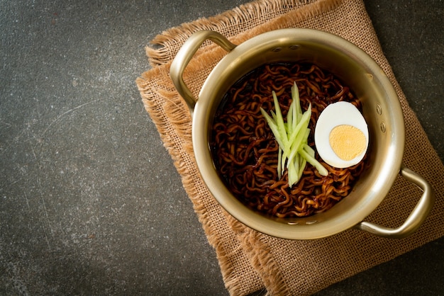 Koreański makaron błyskawiczny z sosem z czarnej fasoli z ogórkiem i gotowanym jajkiem (Jajangmyeon lub JJajangmyeon) - koreański styl jedzenia