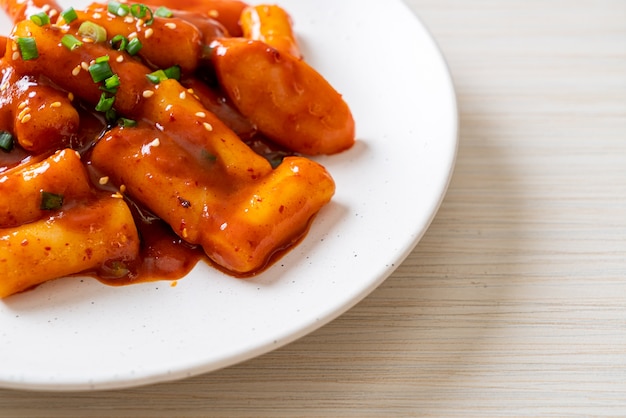 Koreański placek ryżowy z kiełbasą w ostrym sosie (Tteokbokki). Koreański styl jedzenia