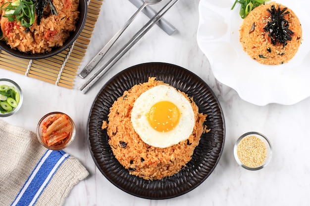 Koreańskie jedzenie: smażony ryż Bokkeumbap lub Kimchi, tradycyjny koreański przepis smażony ryż z Kimchi, szczypiorkiem, sezamem, pomidorem i nori (lawerą). Podawany na białej ceramicznej płycie