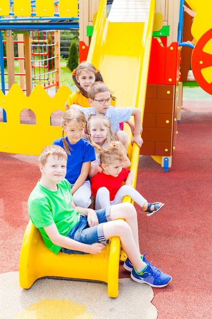 Zdjęcie korki dla dzieci na slajdzie. szczęśliwe dzieci na placu zabaw.