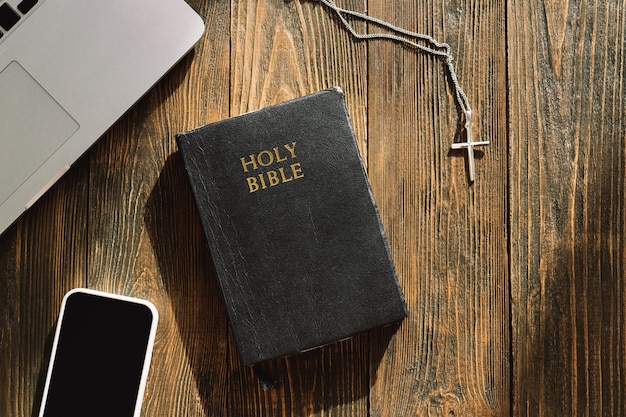 Kościół online niedziela nowa normalna koncepcja biblia telefon komórkowy i słuchawki douszne na drewnianym tle