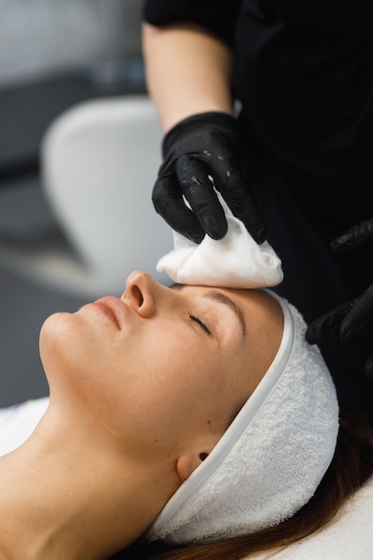 Kosmetolog wykonujący zastrzyk mezoterapii z dermapenem na twarz w celu odmłodzenia w centrum spa