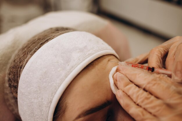 Kosmetolog wykonuje zastrzyki na twarz Koncepcja Spa relaks i samoopieka
