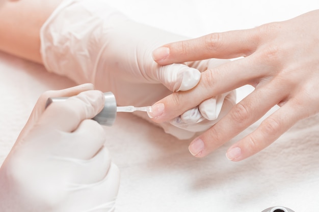 Kosmetyczka nakładająca polskie paznokcie na paznokcie damskie