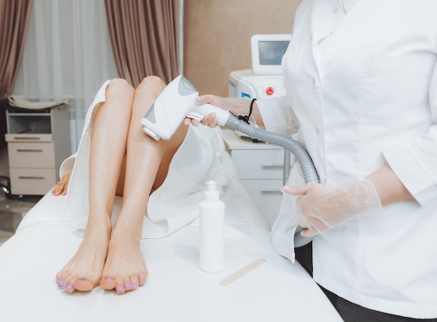 Kosmetyczka usuwa owłosienie na kobiecych nogach za pomocą depilacji laserowej na nogach depilacja laserowa w salonie
